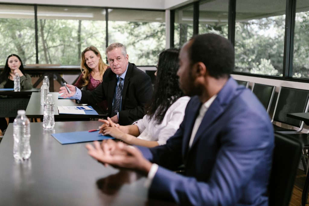 A diverse group of professionals engaging in a collaborative meeting in a conference room setting.