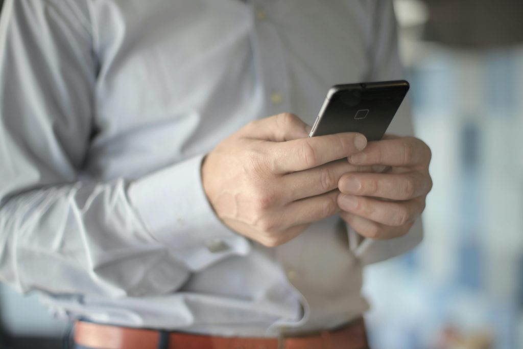 Close-up of a businessman using a smartphone, highlighting business and communication themes.